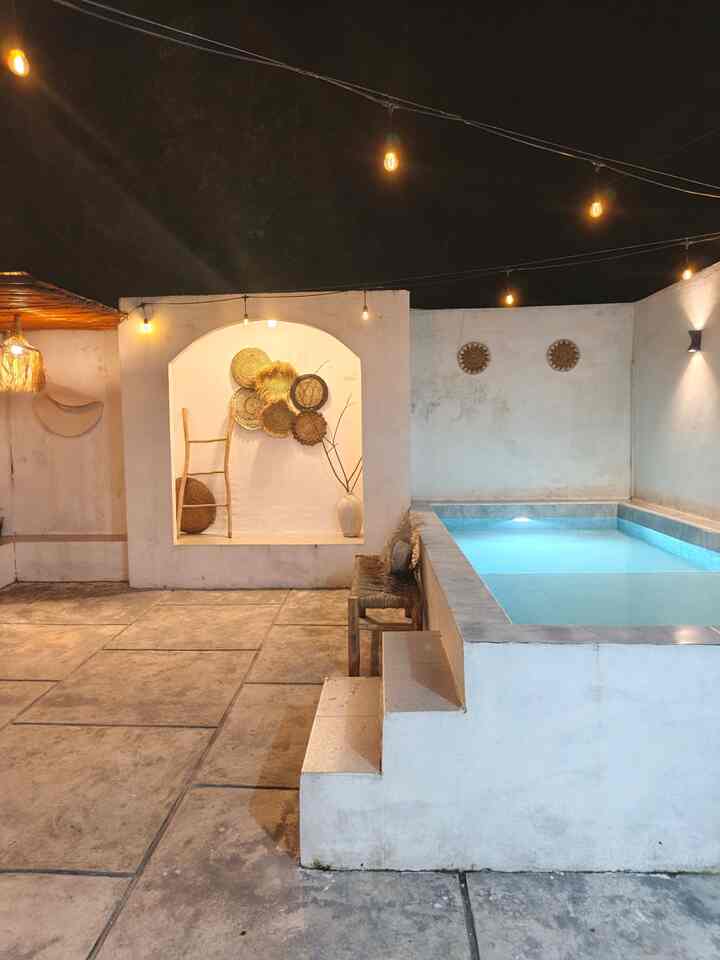 Natural-toned balcony space featuring wall sconces and wood-tone accents in a cozy outdoor setting