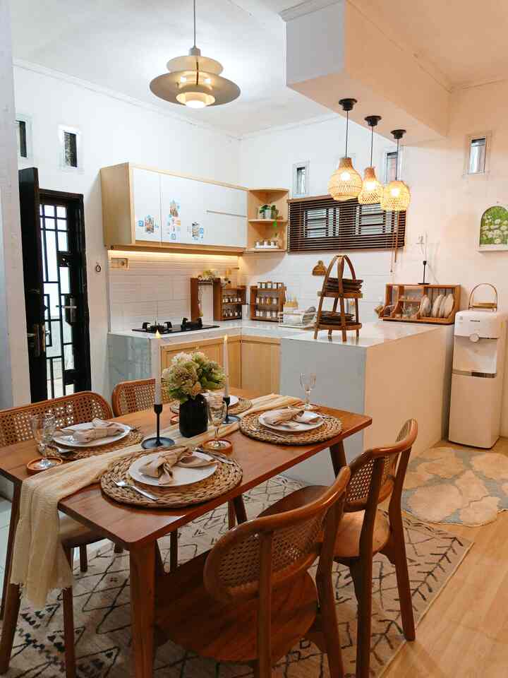 Styling kitchen & dining area 🩵
Hal pertama yang ada di benak waktu renovasi rumah ini adalah harus ada kabinet dapur yang compact dan harus ada meja makan walaupun rumah kami tergolong kecil.
Karna sumber kehangatan di dalam rumah itu salah satunya berasal dari kegiatan masak memasak dan makan bersama. Awalnya agak ragu memasang kabinet dapur berwarna wood & white karena warna nya sudah terlalu banyak di pakai di dapur2 pada umum nya, tetapi karena kami rasa warna kabinetnya cocok dengan styling dan identitas rumah, akhirnya kami memutuskan memakai warna itu. Dan pada akhirnya memang warna wood & white kabinet dapur lebih mudah di styling dengan dekorasi apapun baik yang berwarna natural maupun yang colorfull sekalipun. Karena dapur & ruang makan kami termasuk area open space, area ini sering di ubah ubah styling nya, kadang mood menggunakan warna natural kadang mood manambah dekorasi seperti karpet, taplak meja yang lebih berwarna

#makeoverdapur #stylingdapur #dapurimpian #mejamakan #karpetruangmakan #lampugantung #dispenser #dekorasiruangmakan #candleholder #rakpiring