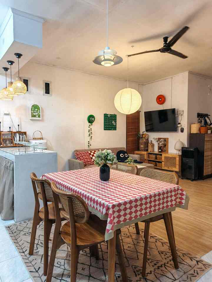 Area open space Ryuto house berukuran lebih kurang 4x7m yang terdiri dari ruang keluarga, dapur dan area makan yang menyatu menjadi satu ruangan. Area ini sangat fungsional dan terlihat sangat lega untuk beraktifitas sehari hari. Penerapan konsep open space sangat cocok di rumah mungil kami membuat keterbatasan lahan bangunan ini menjadi lebih compact dalam konsep open space. Pemilihan furniture dengan banyak penyimpanan  seperti kabinet dapur, kabinet TV, box-box rotan kami gunakan agar penyimpanan terlihat lebih rapi dan tidak berantakan.
Tema ruangan ini sering berubah ubah, Ryuto house yang awalnya suka dengan konsep natural seperti furniture berbahan kayu dan rotan, sekarang lebih di mix dengan dekorasi yang lebih berwarna agar ruangan ini terlihat lebih hidup. Motif checkerboard mendominasi dan terlihat sangat menarik disandingkan dengan furniture berbahan kayu dan rotan. Dapur mungil yang sangat fungsional dengan kabinet berwarna wood & white yang bersifat netral, cukup cocok disandingkan dengan dekorasi full color yang sering kami gonta ganti di area open space ini.
Area open space kami juga ramah anak, di sudut ruangan area koridor menuju ruang tamu, kami tambahkan rak kubos untuk rak mainan beserta box box penyimpanannya. Mainan anak di area ini sengaja kami pajang yang berwarna natural kayu agar terlihat match dengan area ini.

#rumahopenspace #rumahtanpasekat #rumahlega #livingroom #kitchen #diningroom #playroom #lampugantung #karpetruangtamu #walldecor #mejamakan #taplakmeja