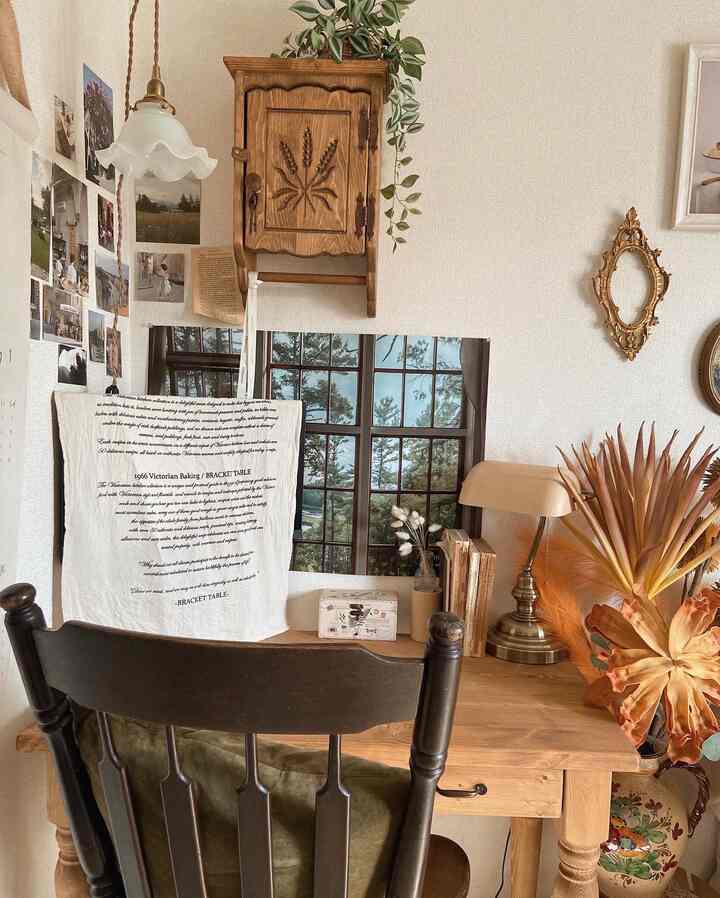 Brown wood tone natural styled home office desk area with posters and warm lighting