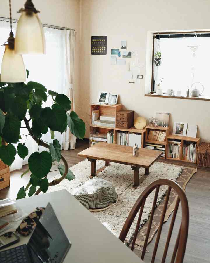 ナチュラルな色調のリビング、木目調のテーブルとラグ、植物が配置され、落ち着いた雰囲気のあるインテリア