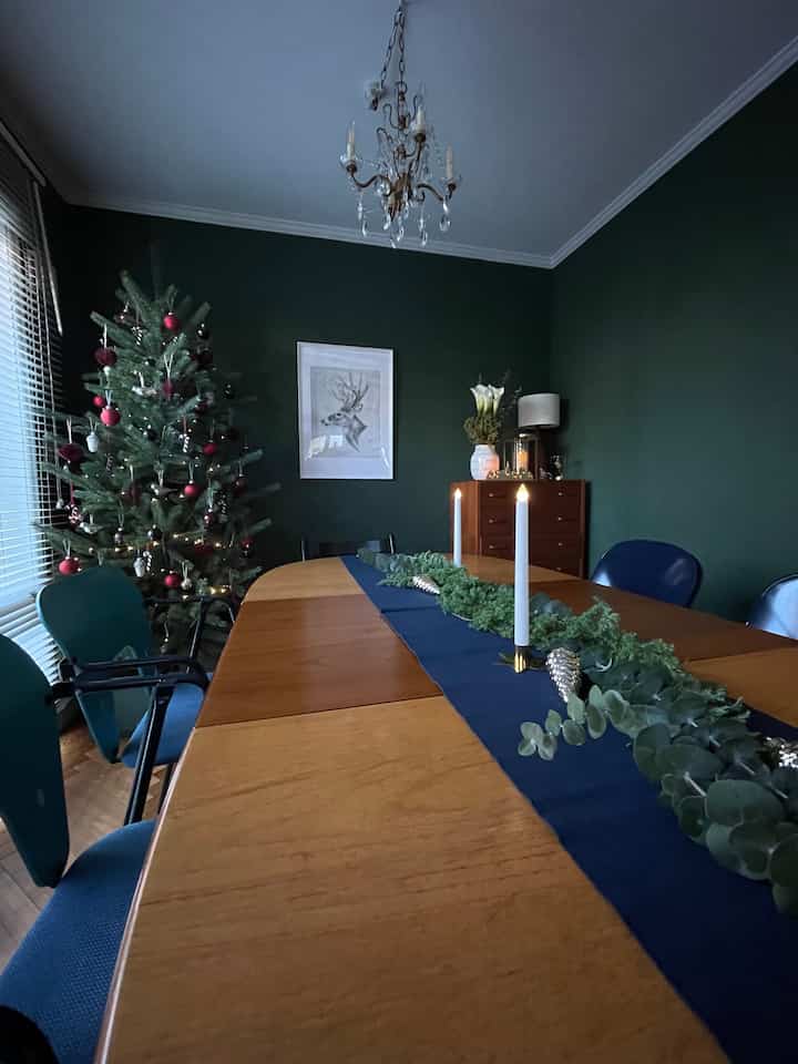 ネイビーの色調が特徴的なダイニングルーム、木製ダイニングテーブルとクリスマスツリー、キャンドル装飾が温かみのある雰囲気を演出するインテリア