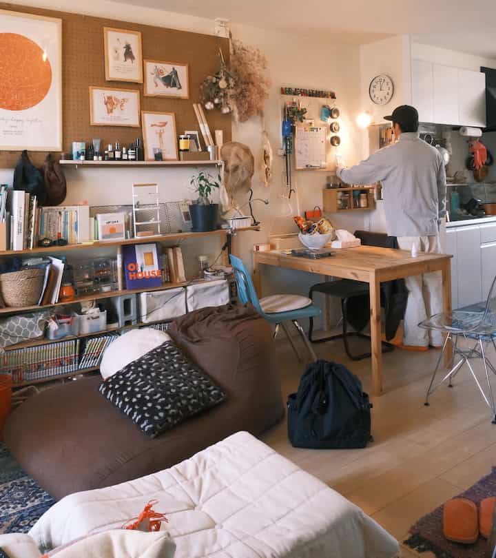Natural-toned single household living and dining area featuring organized storage and remote work setup in a cozy space