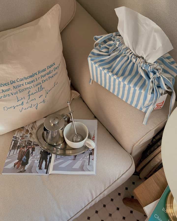 Beige-toned living room sofa featuring a blue striped tissue cover and tea accessories in a cozy Korean interior space
