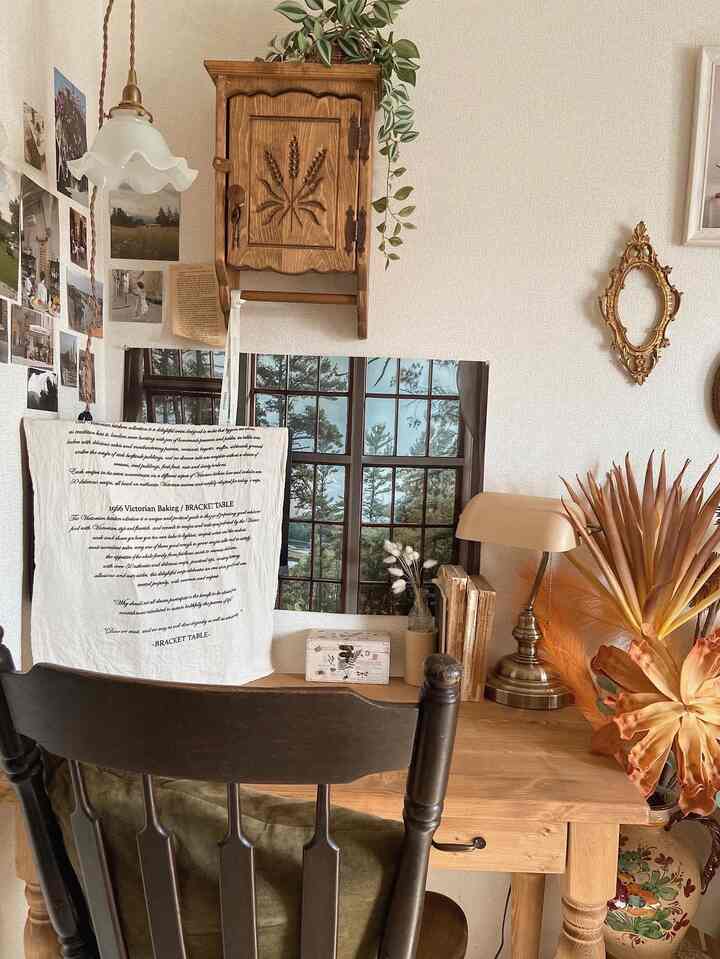 ナチュラルな色調のホームオフィス、木製デスクとヴィンテージ風の小物が配置された雰囲気のある空間