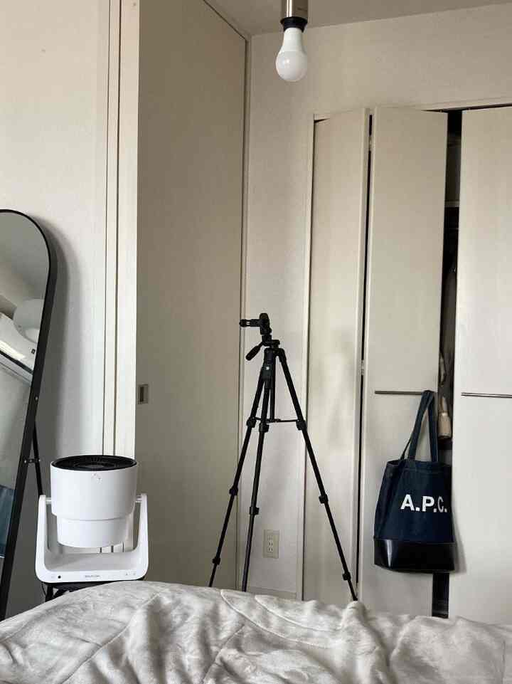 White and black tone bedroom featuring an arch-shaped mirror and a circulator with a tidy atmosphere