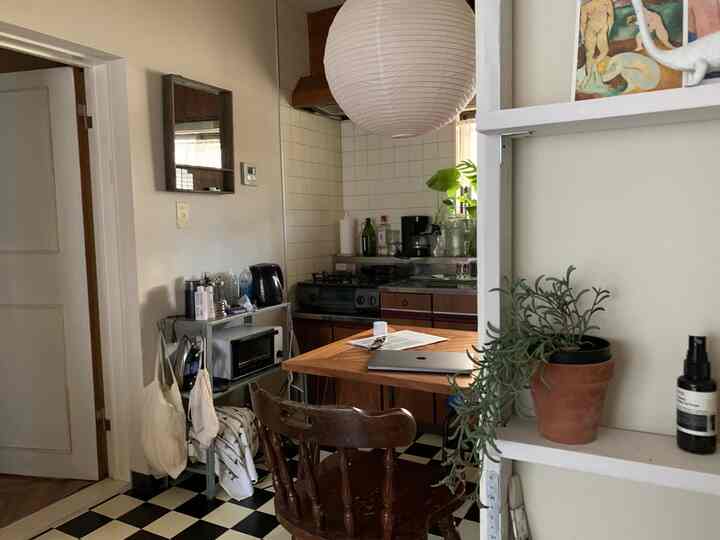 白と茶色のトーンのアパルトマンのダイニングキッチン、ナチュラルな家具と植物が配置された落ち着いた空間