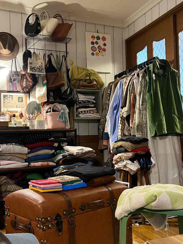 Natural-toned small dressing room featuring clothes racks and a green stool, creating a cozy atmosphere