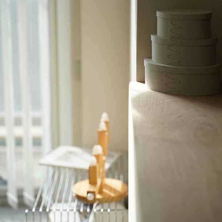 ナチュラルカラーのカウンターキッチン、ラワン材の天板と整頓された収納ボックスが配置された温かみのある空間