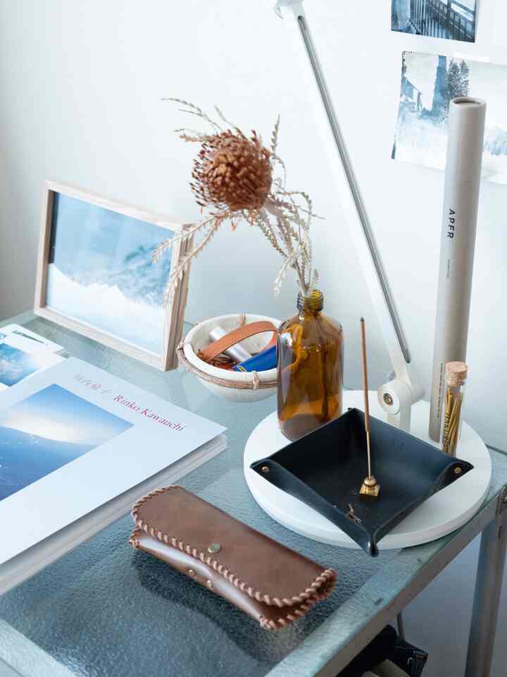 ナチュラルカラーの一人暮らしのデスクにインセンス用トレイや小物が置かれた落ち着いた空間