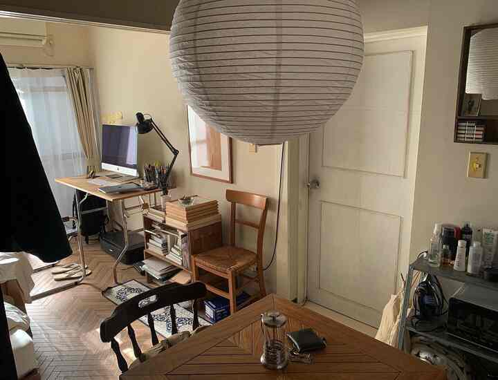 White and brown toned dining room featuring wooden table, vintage chair, and a home office area creating a natural atmosphere