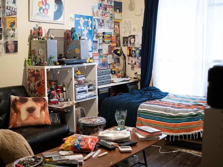 Blue and brown toned compact single household bedroom living room with sofa and bed, cozy atmosphere