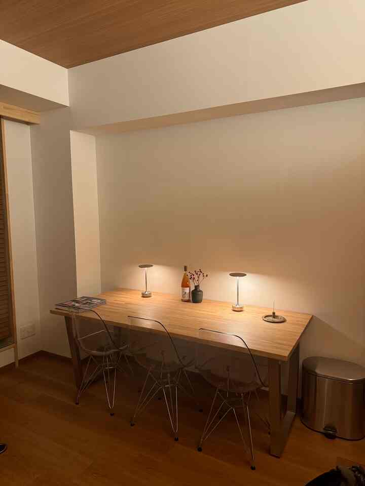 Wood tone dining room featuring transparent chairs and simple lighting, creating a cozy and spacious atmosphere