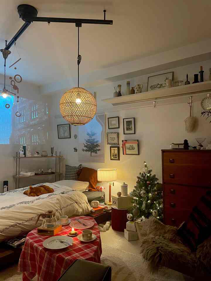 Cozy bedroom with warm wood tones and natural style featuring a lit Christmas tree and ambient lighting