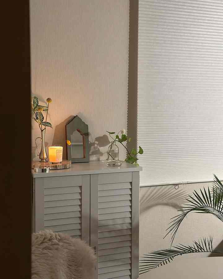 柔らかなホワイトトーンのシューズラックと植物が配置されたナチュラルで温かみのある空間