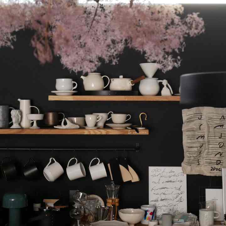 Natural wood-tone modern kitchen featuring white ceramics and black accent wall