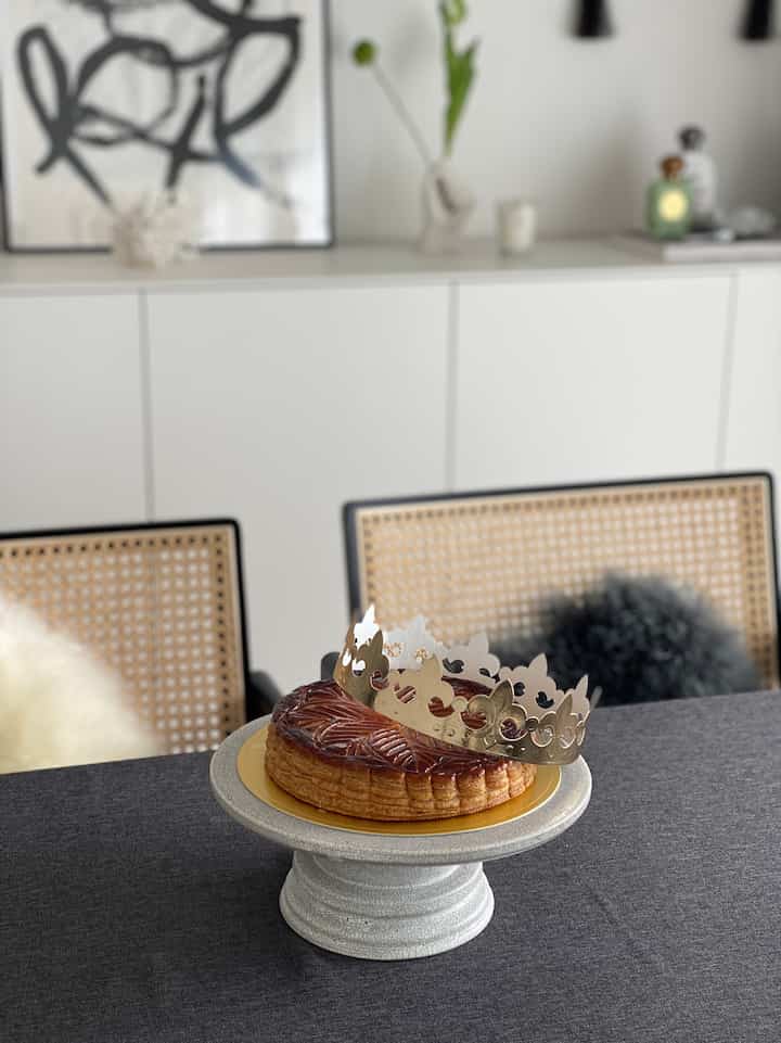 白い収納と黒のテーブルクロスがあるダイニングルーム、丸いテーブルの上にケーキが置かれた、清潔感のあるモダンな空間