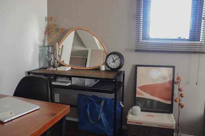 グレーの壁とブラウンのテーブルがある二人暮らし向けのリビングのミニマルなホームオフィス