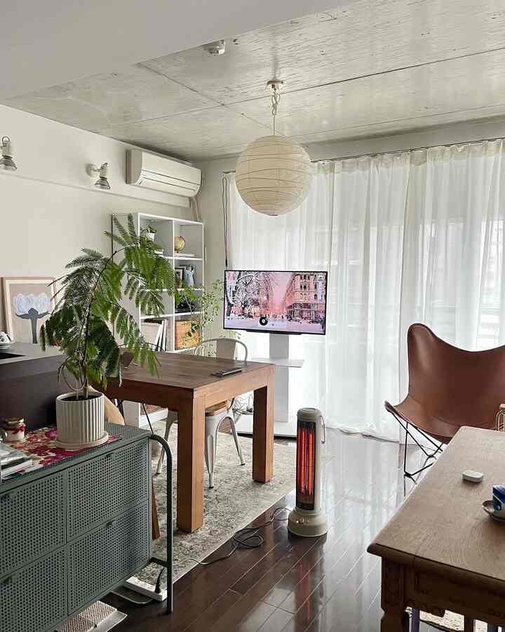 明るい自然な色調の1LDK一人暮らし用リビングダイニング、木製ダイニングテーブルと金属椅子、紙製ペンダントランプが配置された落ち着いた空間