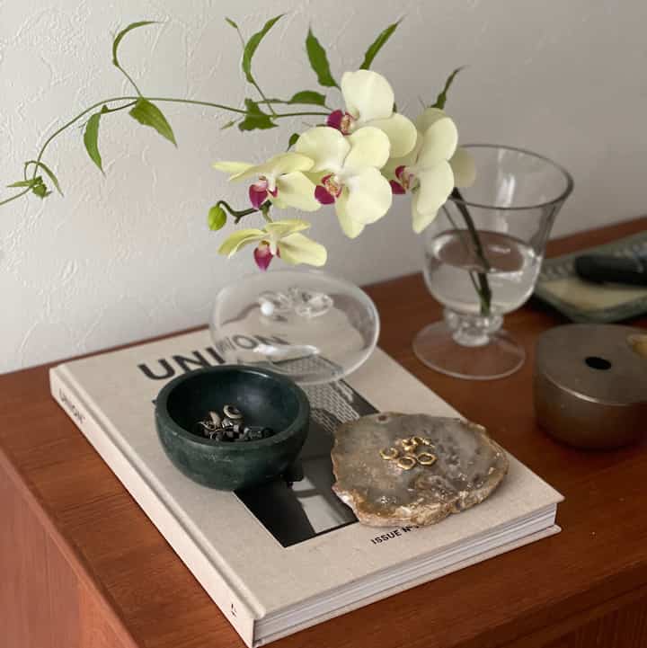 ナチュラルなブラウン調の玄関、花瓶とヴィンテージ家具が配置されたシンプルで雰囲気のあるインテリア