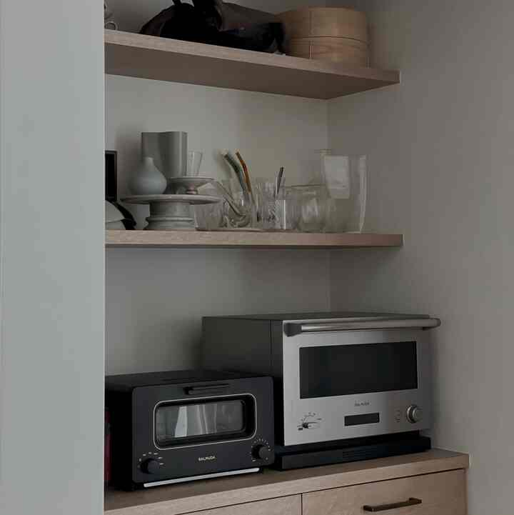 ナチュラルな木目調と透明なガラス器が配置されたパントリー、シンプルで整ったキッチンインテリア