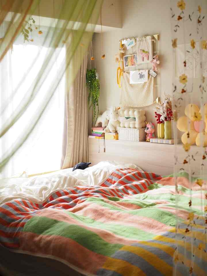 柔らかな自然光とカラフルなブランケットが配置された雰囲気のある寝室