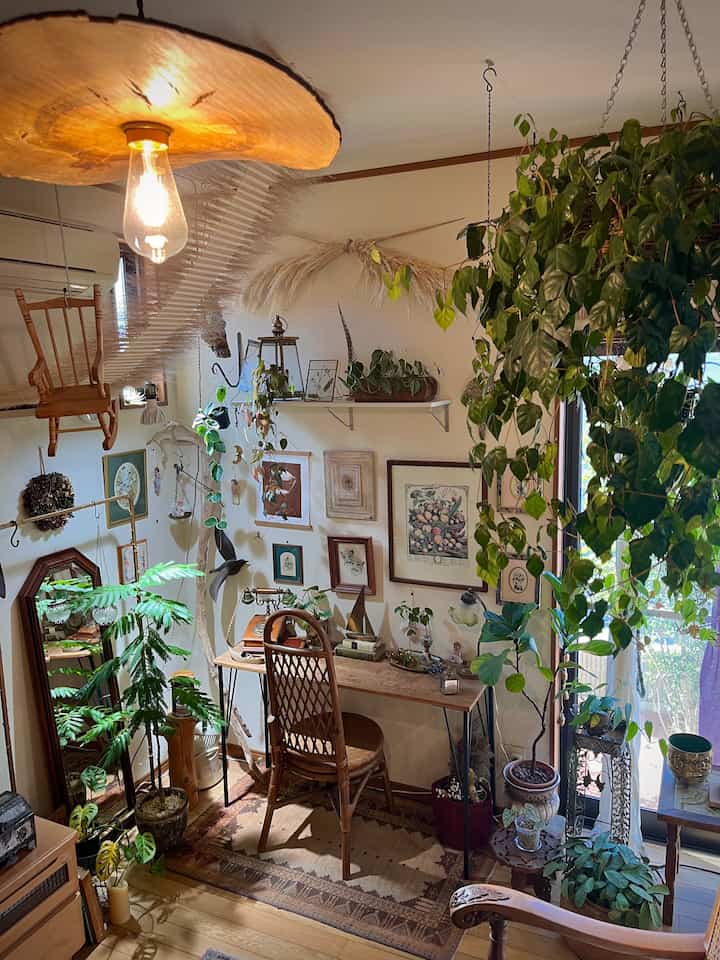 ナチュラルな木目調家具と多様な観葉植物が配置されたヴィンテージ風リビングの雰囲気あるインテリア