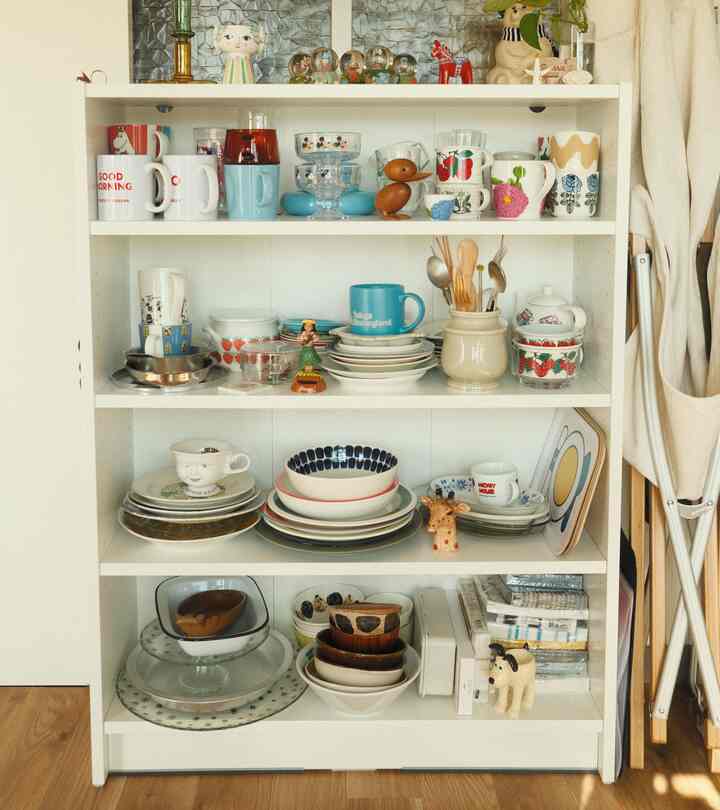 白を基調とした本棚にキッチン用品と小物が整然と並べられた、一人暮らしの整った収納スペース