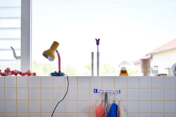 黄色の目地が印象的な白いタイルのキッチン、シンプルで清潔感のある雰囲気