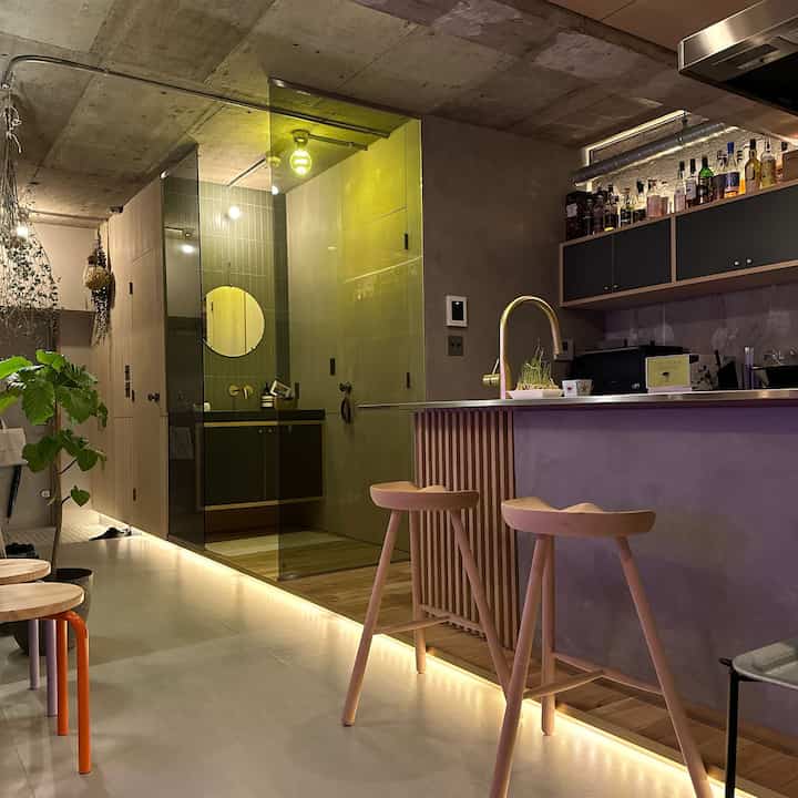 Natural-toned home bar area featuring wooden stools and string lights creating a cozy atmosphere