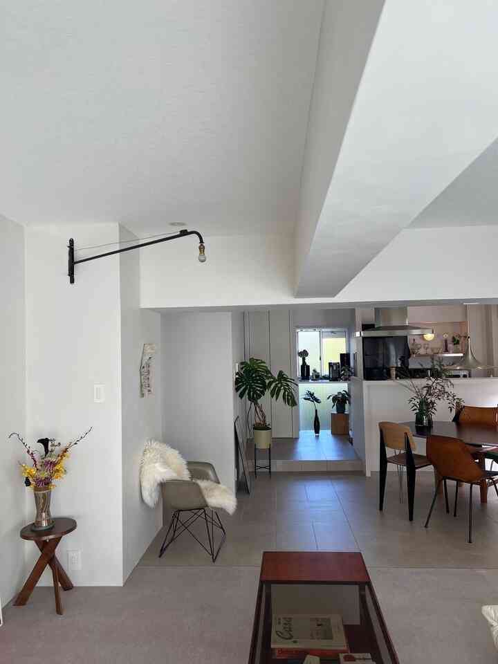 白と木目調が調和したキッチンダイニング、低い天井と大きな窓で抜け感のあるモダンなインテリア