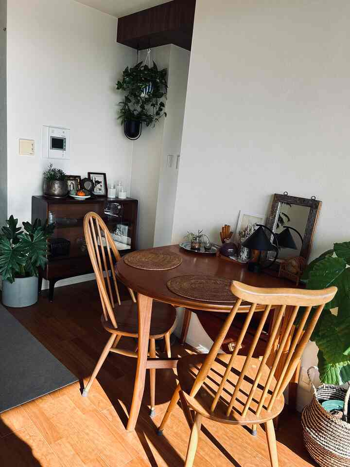 Natural wood tone dining room featuring a vintage gateleg table with Muji rattan placemats, creating a warm and cozy atmosphere