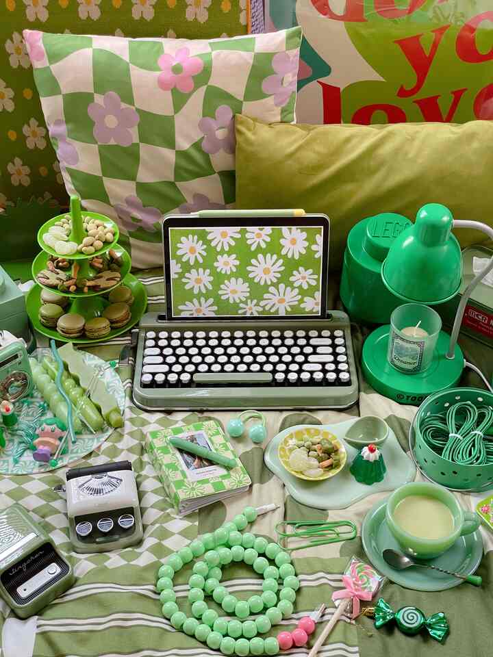 カラフルなグリーントーンのミッドセンチュリーモダンとレトロが融合したインテリア、多彩な小物とキーボードが配置された雰囲気のある空間