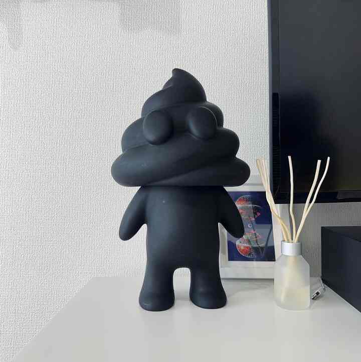 黒いフィギュアとディフューザーが置かれた白いテーブルと壁のシンプルな一人暮らしのワンルーム、モダンなインテリア