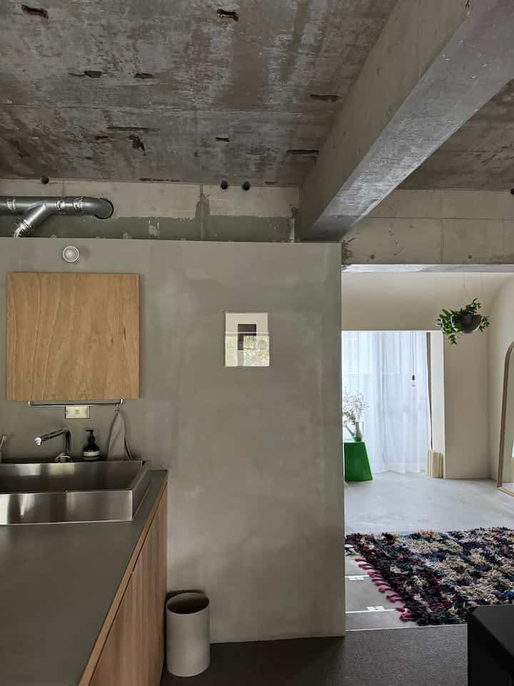 ウッドトーンとホワイトの玄関洗面スペース、露出コンクリート天井と洗練されたモダンなインテリア