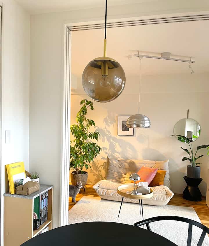 ベージュと木目調のリビング・ダイニング、ペンダントライトとソファが配置されたナチュラルモダンな印象的な空間