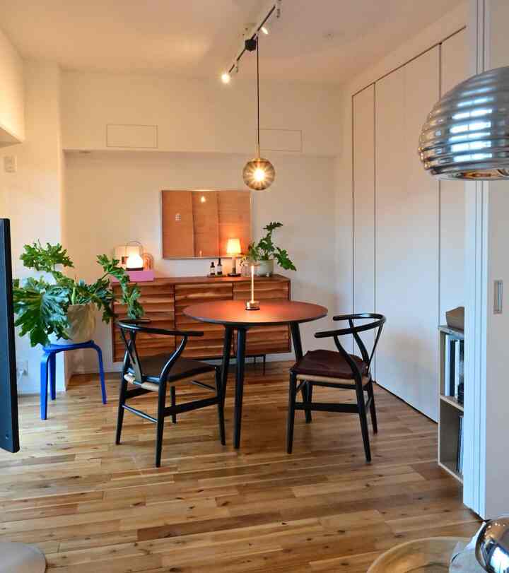 Wood tone flooring and furniture with black dining table and chairs in a two-person dining room creating a natural atmosphere