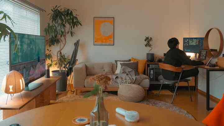 ベージュと木目調の調和が美しい12畳のワークスペース、ソファやデスク、多様な植物が配置された雰囲気のある空間