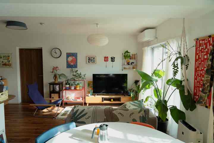 ホワイトとウッドトーンが調和した北欧風のリビング、ソファと植物が配置された雰囲気のある空間