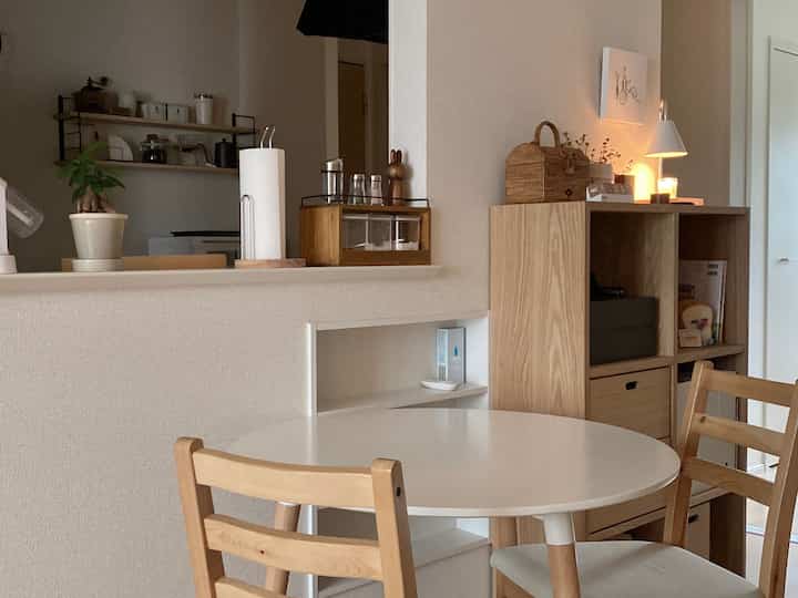 Beige and white toned dining room featuring wooden furniture and candles with a cozy natural interior atmosphere