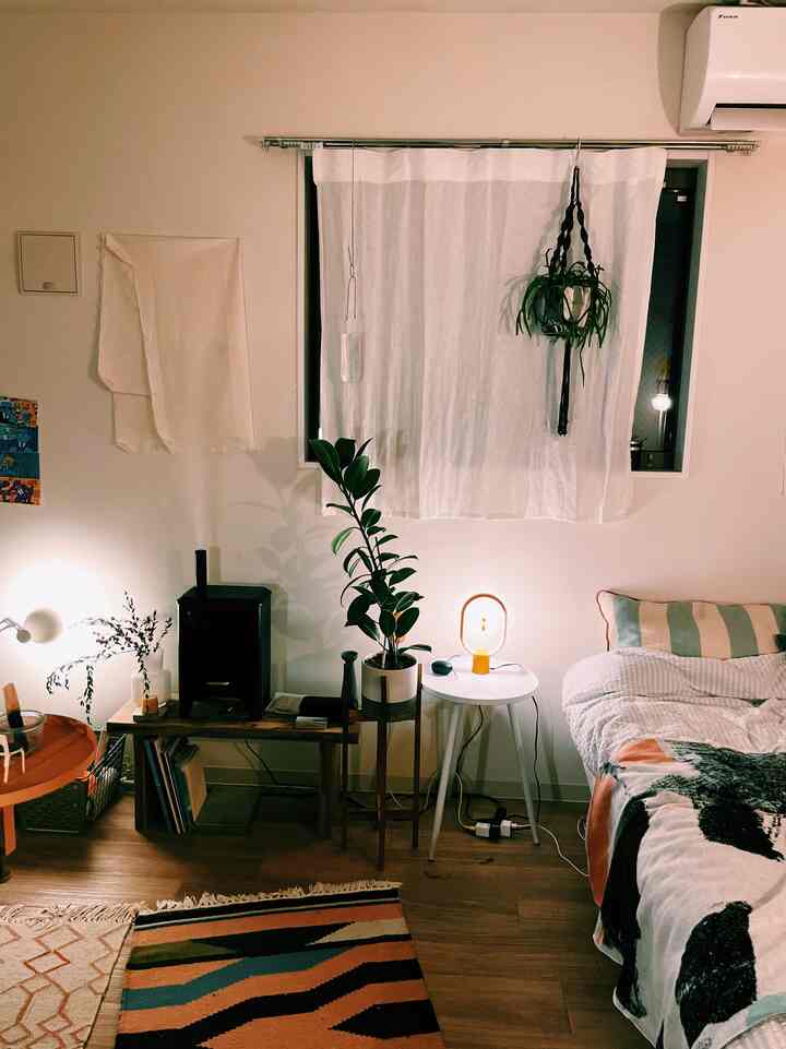 Natural beige and wood-toned 1K bedroom featuring plants and warm lighting, creating a cozy atmosphere