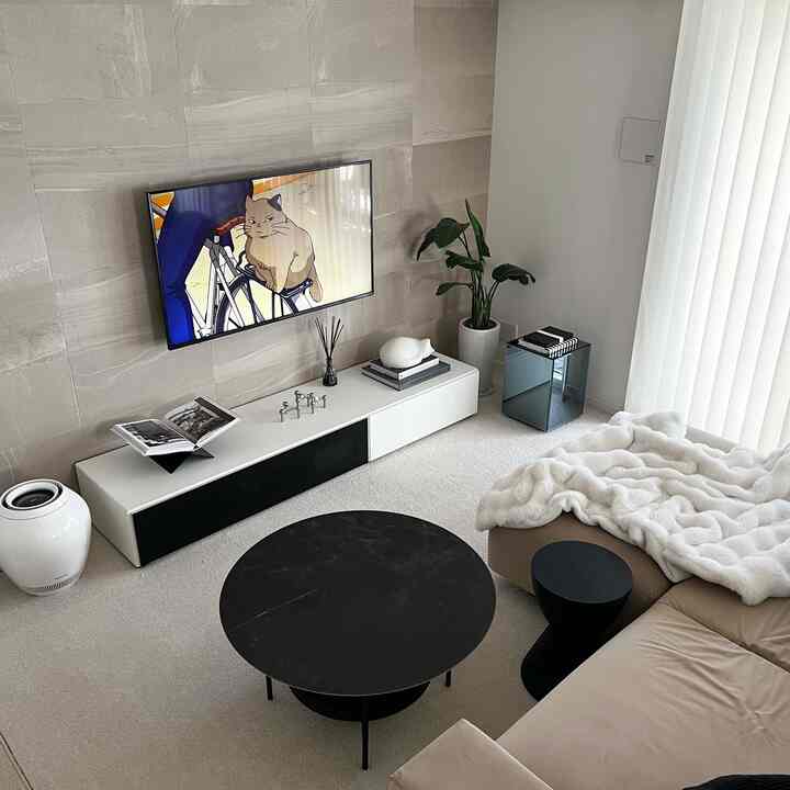 ナチュラルな色調のリビング、ベージュのソファと丸いコーヒーテーブルが配置された落ち着いた空間