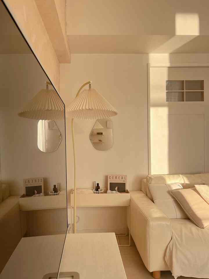 Ivory-toned living room featuring an ivory sofa and floor lamp with warm, simple ambiance