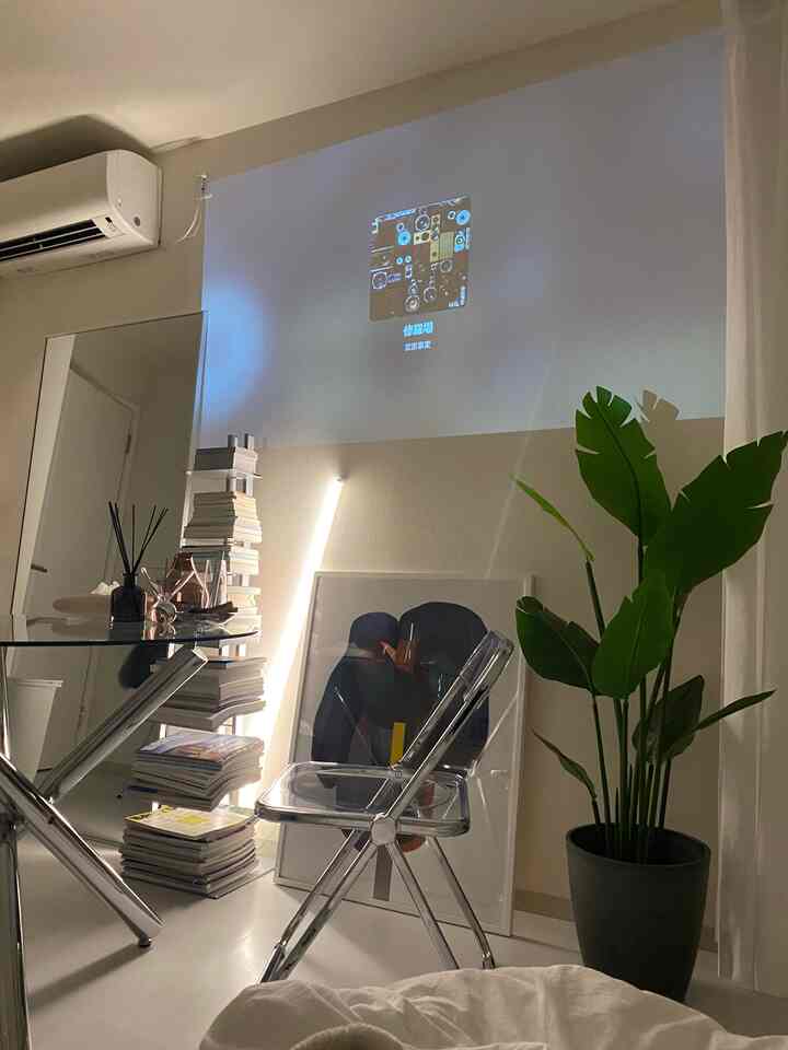 Navy-toned wall featuring transparent chair and LED indirect lighting in a single household home cinema setup
