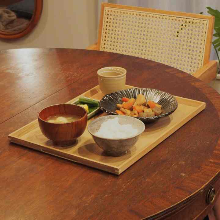 木目調のダイニング、木製トレイと食器が配置された木のダイニングテーブルのある雰囲気のある空間