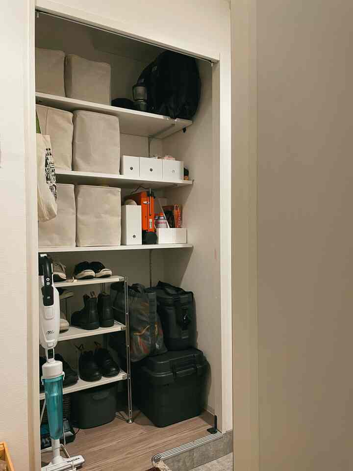 ベージュとナチュラルカラーの狭い玄関収納、靴棚やさまざまな収納ボックスが整理された雰囲気のあるインテリア