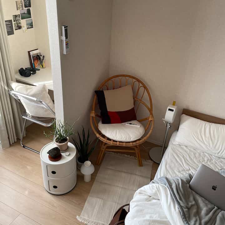 Natural wood tone bedroom for single household featuring a bed, desk, and cozy home office setup