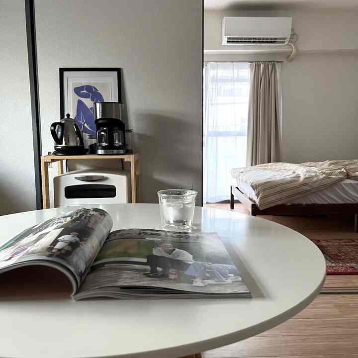 白と茶色のトーンでまとめられた1LDKのダイニングルームと寝室、ホームカフェが配置された雰囲気のあるインテリア