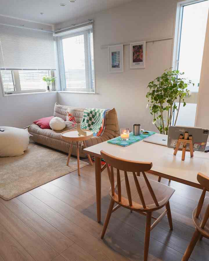 Beige and wood-tone living room featuring a beige sofa, wooden chairs, and a candle on the table in a natural setting