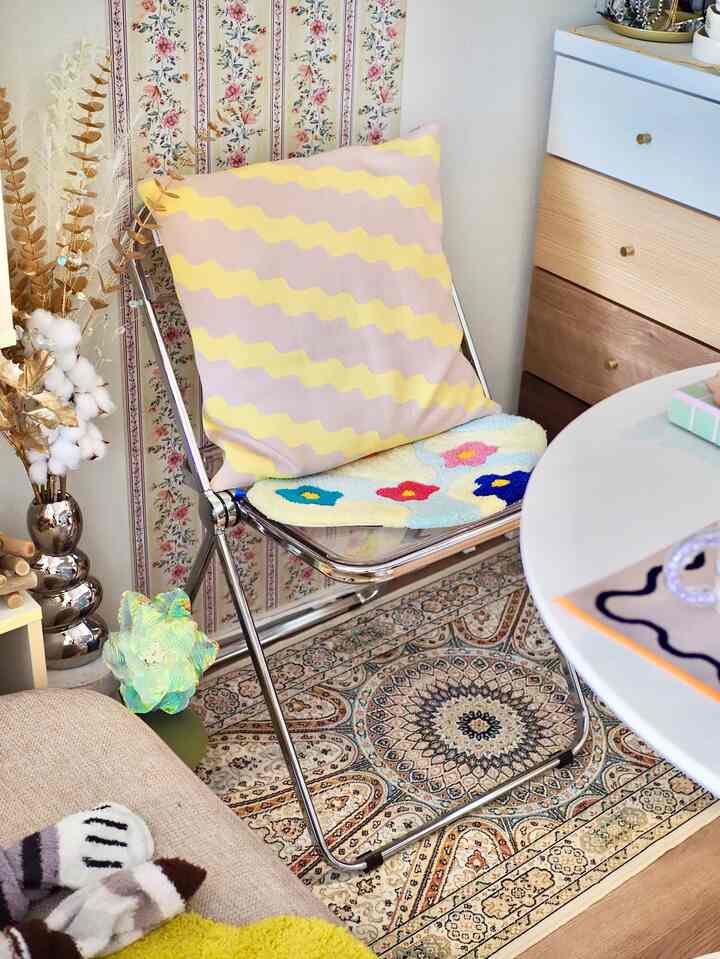 パステルとベージュ調のリビング、花柄壁紙と模様のあるラグがアクセントの落ち着いたシンプルな空間